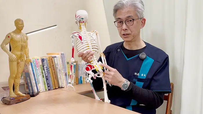 仙腸関節を指さし体幹矯正を解説する青木院長